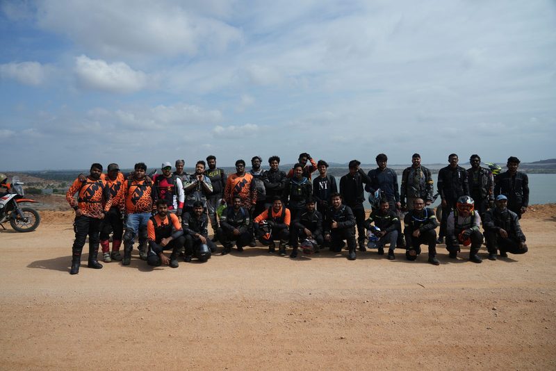 A large group of riders gathered by a reservoir outside Hyderabad
