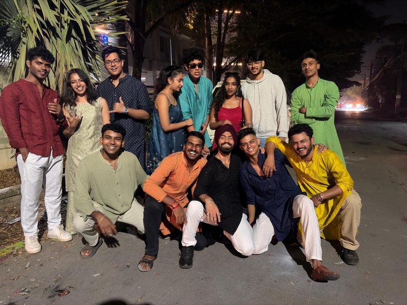 A group in festive kurtas posing together on the street on Diwali night