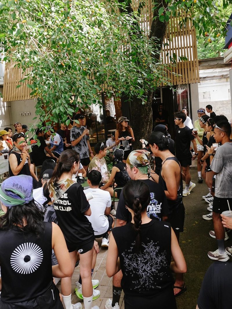 A run club crowded together over coffee after a morning run